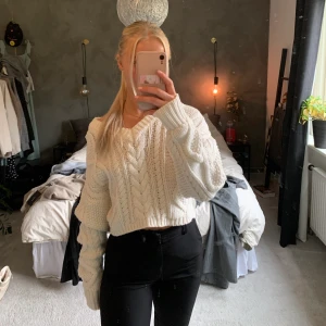 Vit stickad tröja med knyte i ryggen - Jättefin och varm stickad tröja från NAKD. Knyte i ryggen som man själv kan knyta. Sparsamt använd ca 3 gånger. Säljer då jag inte använder. 