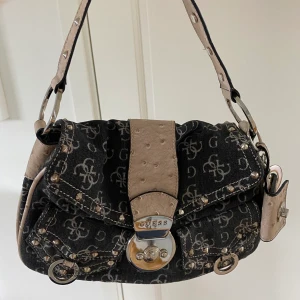 Guess väska - En blå/svart vintage Guess väska med beiga och silvriga detaljer. Väldigt bra skicka med många förvaringsfack.💕
