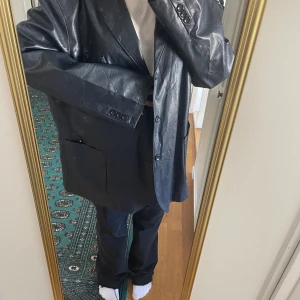 Oversize skinnjacka i mörkblått - (Vet ej om äkta skinn eller ej). Köpt second hand så står ingen storlek men passar allt från M-XL beroende på vilken passform man önskar (jag är en M). Har axelvaddar 😍 Färgen syns tyvärr dåligt på bild.. men vid intresse kan jag skicka bättre bilder!