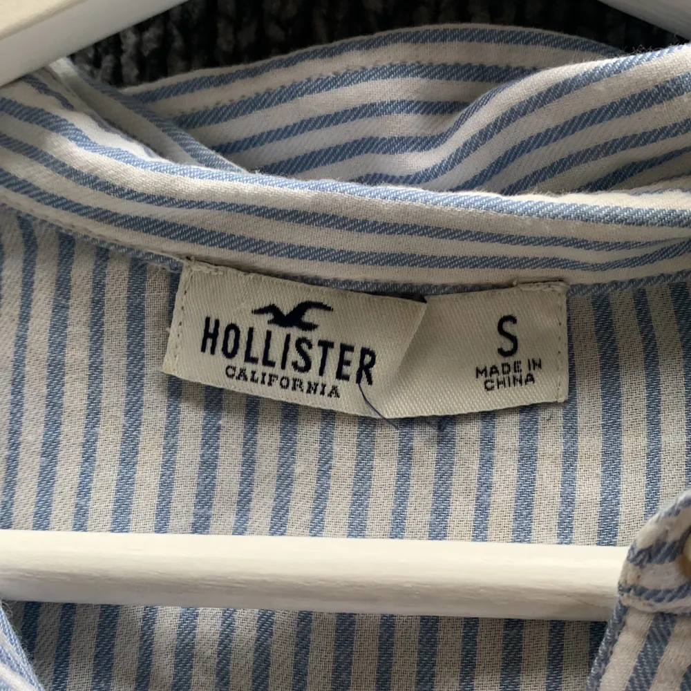 En vit, blå randig strandskjorta från Hollister. Skriv för fler bilder. Toppar.