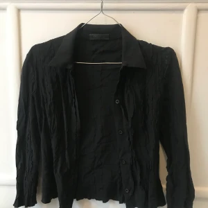 Prada blus - Super söt Prada topp som har trekvarts ärmar. Den har räfflade detaljer på utsidan och är relativt kort i modellen. Super fin som fest topp!