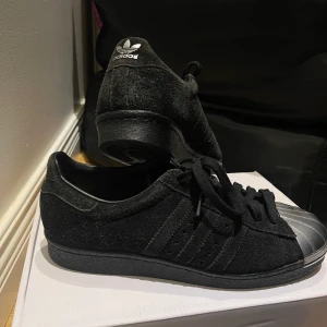 Adidas superstars - Skorna är i okej skick, de är lite slitna har blivit lite ljusare i färgen men har inga större eller synliga skador. Mocka liknande material.