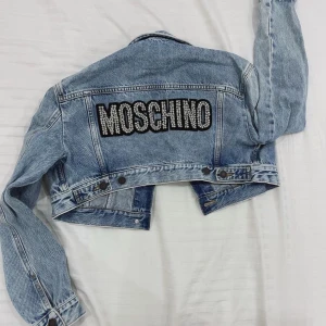 Moschino x hm jeansjacka denim med stenar/nitar - Säljer denna sjuukt snygga jeansjackan från moschino x hm limited edition samarbetet!💗 Aldrig använd och med lappen kvar:) lånade bilder, bara att fråga om egna