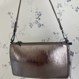 Väska mango - Fin axelväska från mango, helt oanvänd med prislapp kvar. Bandet är kort så den går att ha över axeln. 