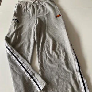 Ellesse mjukisbyxor  - Grå ellesse mjukisbyxor med vida ben! Så sköna men tyvärr lite korta på mig som är 175 cm, skulle passa någon som är under 170! Storlek 36 så passar xs-s:)