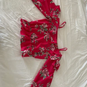 Rosa blommtröja  - Jättefin tröja, blus, med volanger runt nacken, armarna och midjan. Välanvänd och skicket är som nytt. Passar mig som brukar ha storlek S. Skriv för fler bilder. Köparen står för frakt 🌸