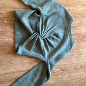 Stickad tröja  - En kroppad stickad tröja med en knut framtill säljer för den är för liten