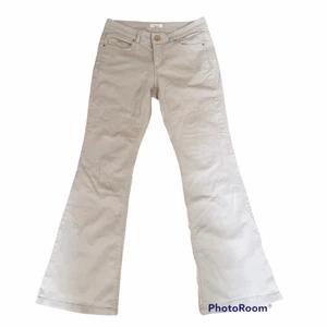 Beige bootcut jeans - Vintage lågmidjade bootcut jeans i färgen beige och ett litet spår av rosa (Färgen är ungefär som på den andra bilden). Den är stretchig och är bekvämt att ha på sig dessutom passar byxorna med allt. Midja: 74 cm (37 tvärs över) Innerbenslängd: 74 cm 