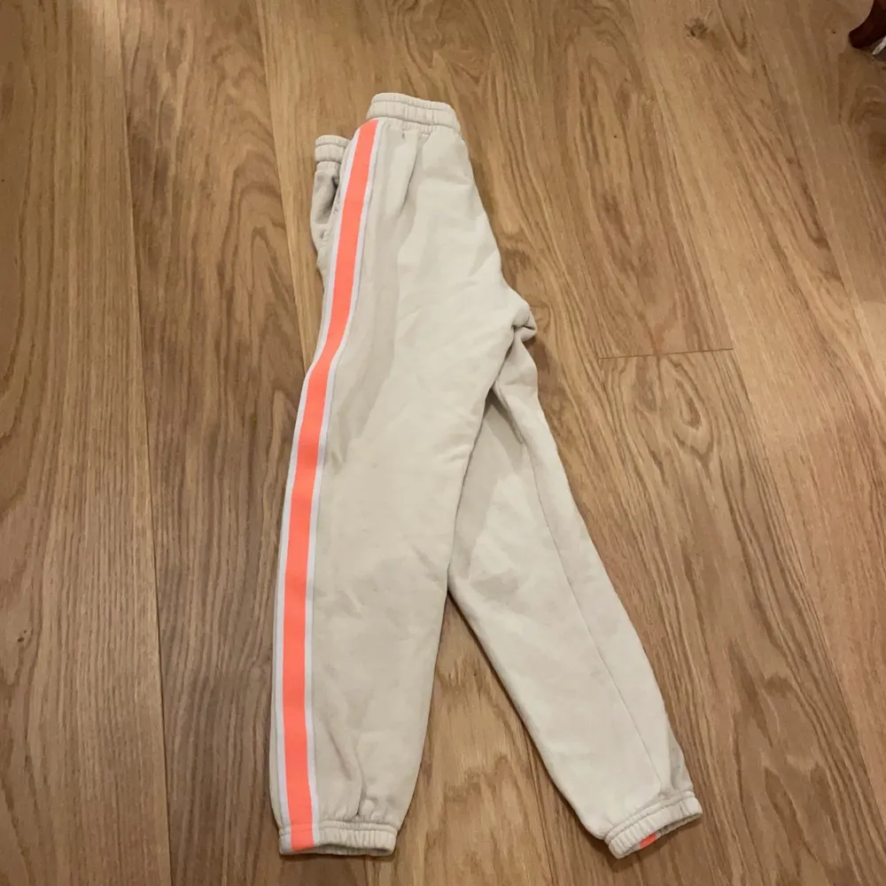 Det här är ett par kräm färgade byxor, de har också ett rosa/orange sträck på båda sidorna. 💗 Mjukis byxorna har också fickor. Själv tycker jag de är jättesköna och stretchiga 🎸⚡️. Jeans & Byxor.