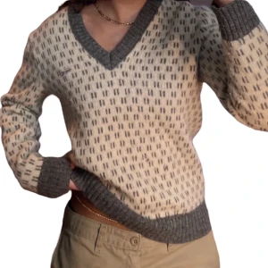 Stickad lacoste tröja - Vit/grå stickad tröja från Lacoste. Supermysig men använder den inte längre. Den har två små hål på framsidan, men det är inget man riktigt lägger märke till me tanke på mönstret 