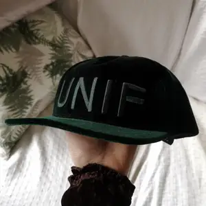 Mörkgrön keps i sammet från UNIF