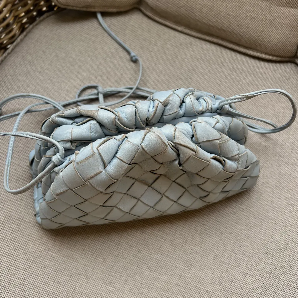 (Säljer åt en kompis) En väska från Bottega Veneta i en jätte fin ljusblå färg. I modellen pouch. Inköpt på Vestiare Collective för lite mindre än 1 år sedan. Dustbag ingår. Nypris 21600kr, men säljes för 6500kr pga att den har slitningar.. Väskor.