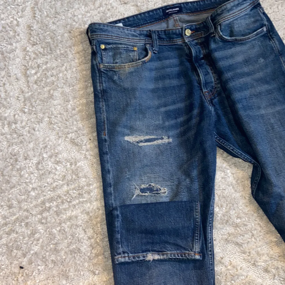 A pair of bluejeans in size 36/36 or XL. They have a ”ripped jeans” design and are barely used. Apart from the rips that show on the pictures the jeans also have ripping details on each back pocket. These jeans have a quite loose fit, im pretty big tough . Jeans & Byxor.