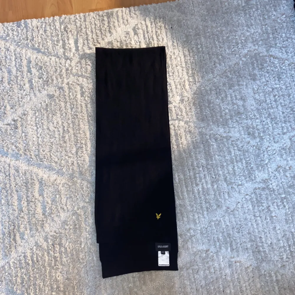 En svart bred stretchig halsduk från Lyle&Scott. Använd fåtal gånger då jag fått många komplimanger.. Accessoarer.
