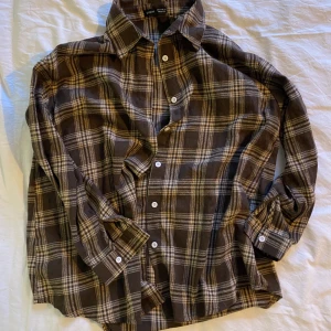 Mjuk Rutig Skjorta - En mjuk brun skjorta från Shein. Använd 2 gånger och i nytt skick. Fungerande knappar. Storlek S