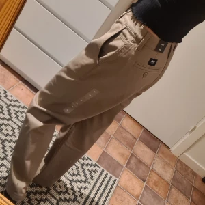 Nya chinos från Vans w26 - Oanvända chinos från Vans med lappar kvar. Lite långa för mig som är ca 155cm lång.    Modell: Authentic womans chinos Strl: w26  Färg: beige  Pris: 250kr eller bud  Nypris: 699kr  Frakt: 69kr (spårbar)