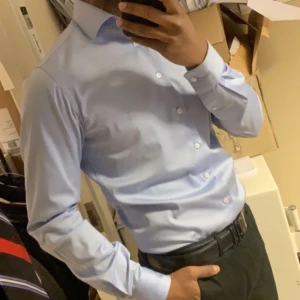 Blå Slim Fit Skjorta - Slim fit skjorta i ljusblå färg från Dressmann i storlek Small