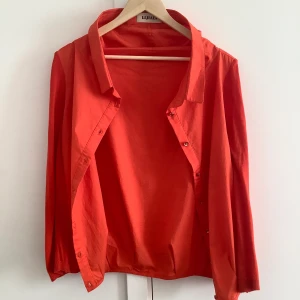 Skjorta från Lijiali strl L - Fin orange skjorta med glimmrande knappar som aldrig använts. Bilderna är lite suddiga då de togs med en ipad, skriv för bättre bilder. 