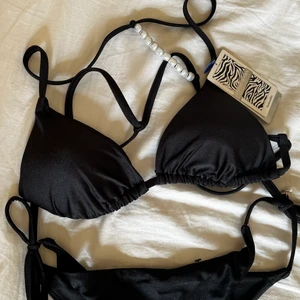 Oanvänd Bikini - Säljer denna bikini från hunkemöller då jag aldrig använt den. Sitter pärlor längst ut på snörena till underdelen. Kan mötas upp i Stockholm, annars står köparen för frakt!💓