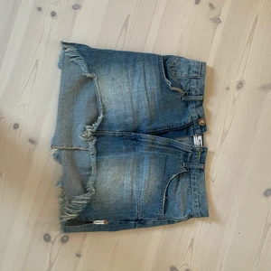 Jeansskjol - Blå jeanskjol. Längre bak och kortare fram. 