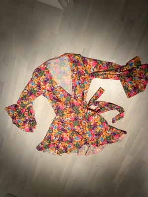 Omlottklänning - Somrig och färgglad omlottklänning, aldrig använd (prislapp kvar).  Köpt i Spanien