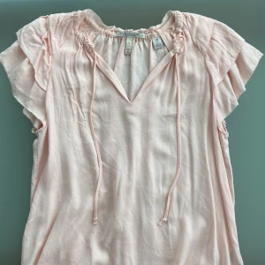 Rosa topp - En super söt baby rosa topp med volanger på axlarna. M men sitter även bra på mig som vanligtvis har S. Använd ett fåtal gånger så i bra skick!