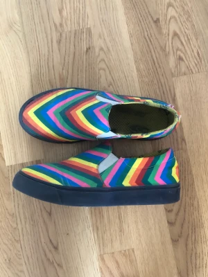 Regnbågsmönstrade skor - Ett par Vans-liknande skor i regnbågsmönster köpta på second hand. Går att användas som dem är men rekommenderar att ha i fotsula. Storlek 38