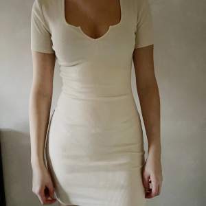 Jättesnygg tight gräddvit klänning med fin detalj vid bröstet. Aldrig använd, säljs pga inte min stil <3