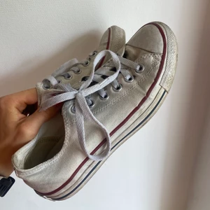 Vita Converse - Låga, vita gonverse i fint skick. De har små slitningar där fram (se bilder) men är sparsamt använda. 