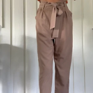 Beiga paperbag byxor - Med matchande skärp att knyta i midjan. Fickor fram. Från HM, strl xs