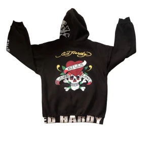 Ed hardy zip up hoodie  - Hej! Säljer nu min ed hardy hoodie, den är i  bra skick och inget slitet.  Den är 56cm lång utan luvan. Skriv privat för närmare bild på trycken och bild på trycket på armen. Köp sker via "köp nu". 