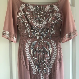 Maxiklänning med paljetter  - Rosa maxiklänning med paljetter, kan bäras som off-shoulder eller vanligt.  Storlek: 34 Märke: Maya Deluxe Använd 1 gång, nyskick.  Köpt för 1 000kr. 