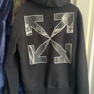 Off white zip hoodie Caravaggio Arrow Slim Zip Hoodie - Köpte den för ett halv år sedan men har inte kommit till användning, använd 2 gånger. Condition är 9,5/10. Har kvitto från när jag köpte den och den är köpt från off whites egna hemsida. Storlek är som en liten medium eller en stor small. Hår på bilden.