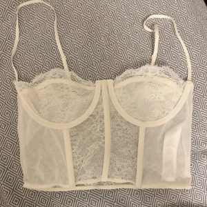 Bralette/Korsett Zara - Vit bralette/korsett i vit spets från zara. Använd en gång