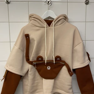 Björn hoodie  - Säljer denna super söta björn hoodie från ”The kawaii shoppu” den är super mysig, varm och den har en björn magväska! 🐻 säljer denna pga att den inte används längre. Tyvärr har ena tassen som ska sitta på armen trillat av men det är lätt fixat! 