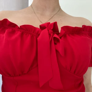 Topp med volangdetaljer  - Söt topp med detaljer i volang vid öppningen, har en röd djup färg och är köpt ifrån Nelly i XS. Aldrig använd! 