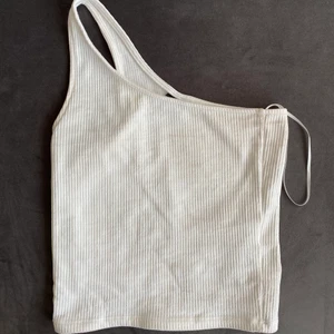 Vit linne från Gina - Vitt ribbat linne från Gina med ett band. Säljer även detta i beige