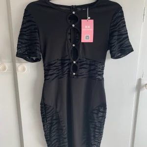 Klänning  - Svart klänning med mesh på sidorna, från missyempire i storlek uk 10 vilket motsvarar storlek 38. Aldrig använt endast testad en gång, tag finns kvar.💕 (Köparen står för frakt) 