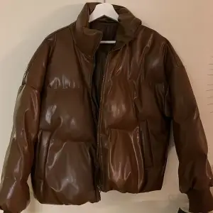 En brun pufferjacket jätte fin streetwear och oversize original pris 699kr