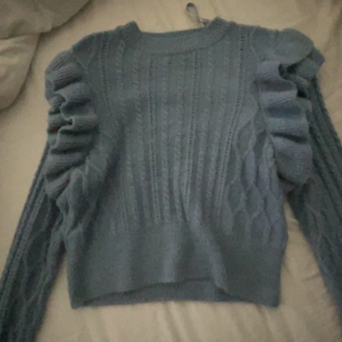 Stickad tröja me volanger