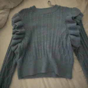 Stickad tröja me volanger - Säljer en stickad volang tröja, andvänd fåtal gånger är i bra skick. Väldigt fin,även dom som har M kan ha denna väldigt stretchig 