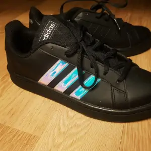 Adidas skor strl. 38, svarta med holographic/irridecsent-detaljer Nyskick. Bara provat dem 2 ggr. Tyvärr hafe jag 38 o 2/3 ,istället för 38 haha 🙃 Nypris 529:- Säljes för 429:-