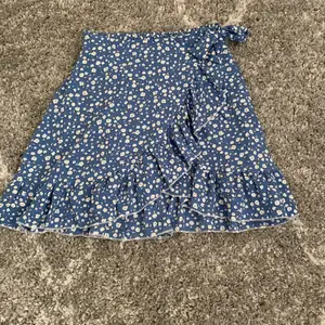 blå kjol med blommor, använd 1 gång.  inga skador. säljer pga att det inte är min stil riktigt och den kommer inte till så stor användning här.  jätte fin enligt mig.  från shein!  köpt för 89kr