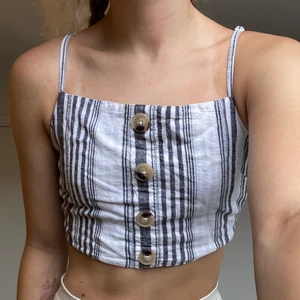 Croptop Gina Tricot  - En vitgrå randig Croptop från Gina Tricot premium quality. Extra knapp finns på tvättrådslappen. Tvättas i 40°C. ✨