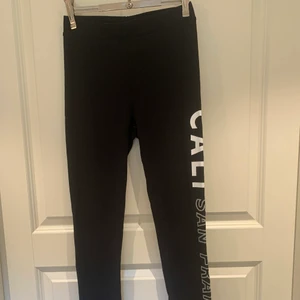 Svarta leggings  - Svarta leggings med vita tryck på sidorna från hm 