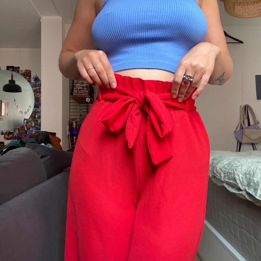 Snygga röda byxor med söt knytning. Använda men i bra skick!. Jeans & Byxor.