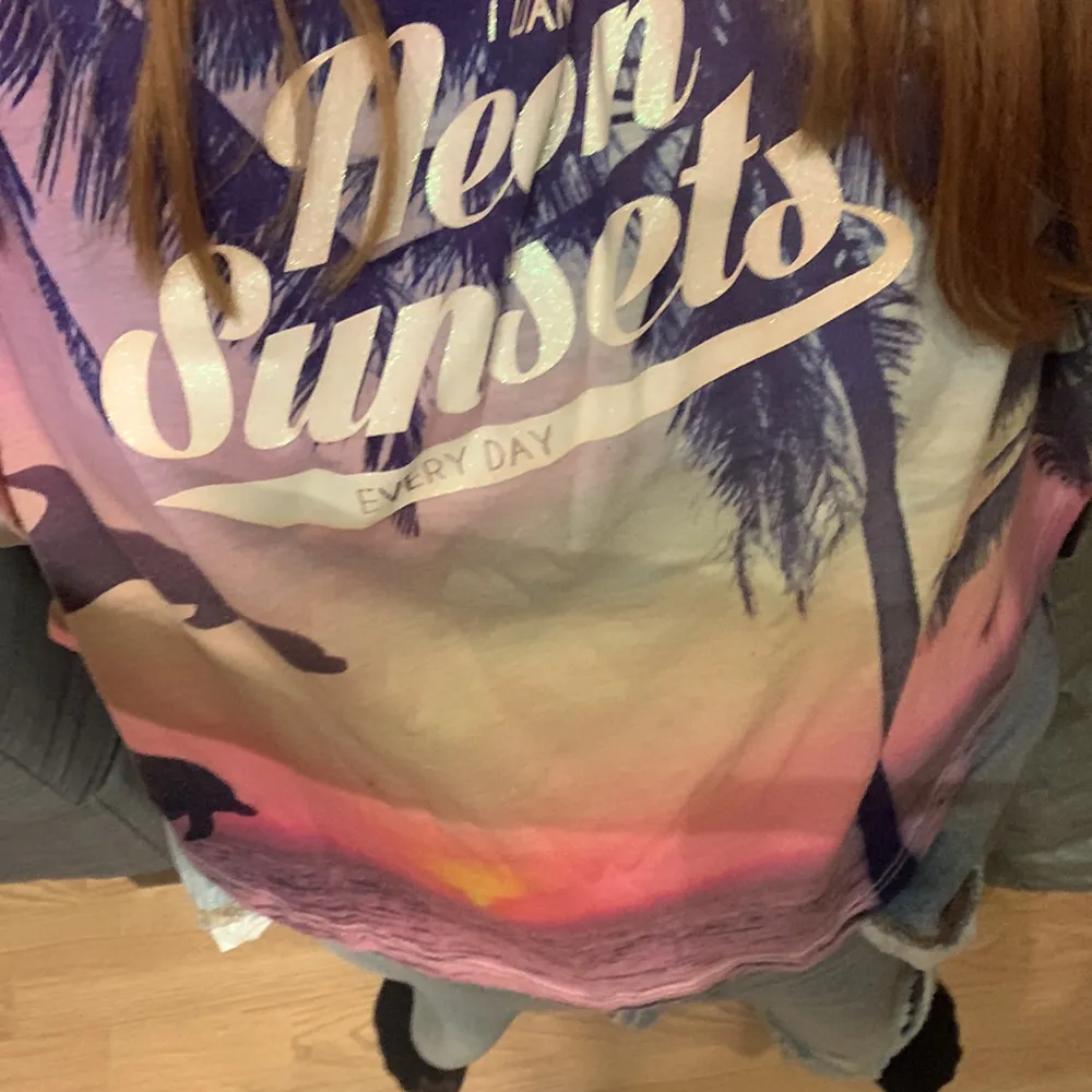 En tröja med ett hav och en solnedgång för det står neon sunset.. T-shirts.