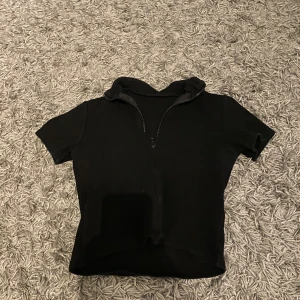 Topp med dragkedja - Svart t-shirt med dragkedja skönt material