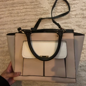 Väska  - Snygg väska med färgerna rosa vit och svart. Rymmer mycket. Avtagbar axelband. 