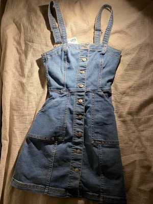 Hängelsklänning  - Söt oanvänd hängelselknänning med fickor. Oanvänd+prislappen är på. Strl 34/36 då den är rätt stretchig. 